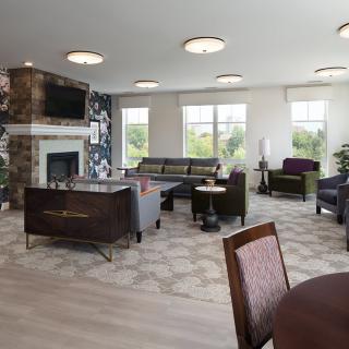 A modern living room with stylish furniture, a fireplace, and large windows.