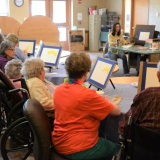 Elderly individuals engaged in a technology session at a community center.