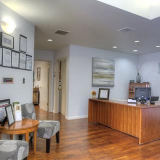 A reception area in an office with a desk, chairs, and decorative elements.