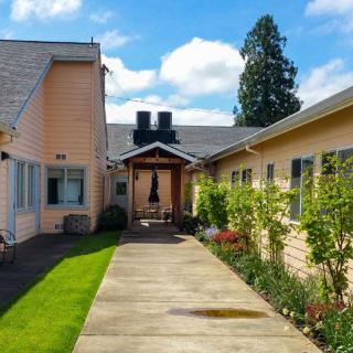A view of a house with a garden pathway under a blue sky.