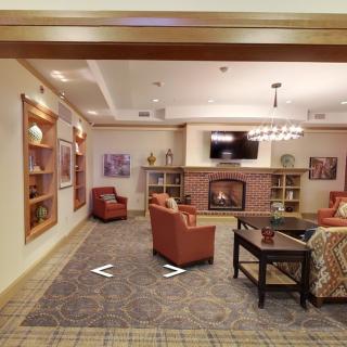 A cozy living room with a fireplace, comfortable seating, and bookshelves.