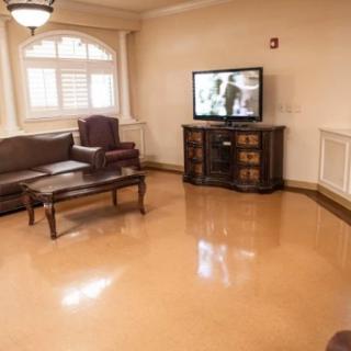 A cozy living room featuring a sofa, coffee table, and television with warm lighting.