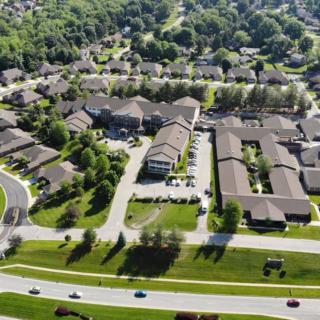 Aerial view of a suburban neighborhood with residential buildings and tree-lined streets.