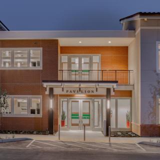 A modern building facade illuminated at night with a prominent entrance.