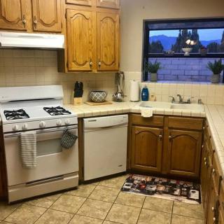 A cozy kitchen with wooden cabinets, featuring a stove and dishwasher.