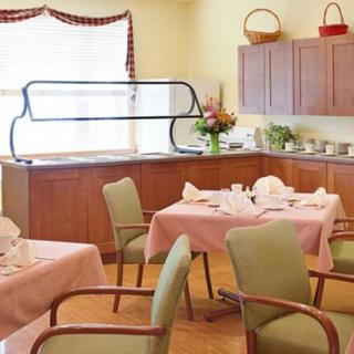 A cozy dining room setup with neatly arranged tables and chairs, adorned with tablecloths and napkins.