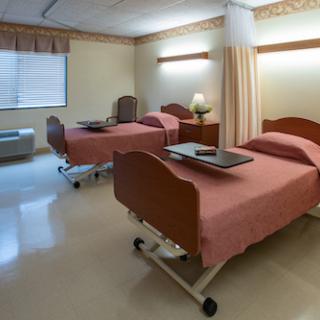 A hospital patient room featuring two beds, suitable for care and recovery.