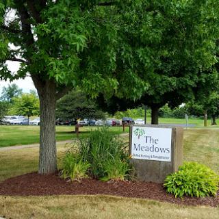Entrance sign for The Modlimes, surrounded by lush greenery.