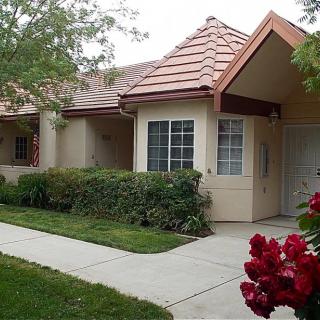 A suburban house with a well-maintained front yard and blooming flowers.