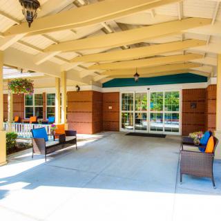 A cozy outdoor seating area with colorful cushions under a covered porch.
