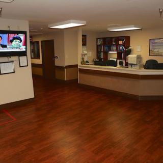 A hospital reception area with a desk and television.