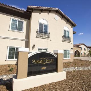A residential building with a prominent sign in front, labeled 'Summit Hills'.