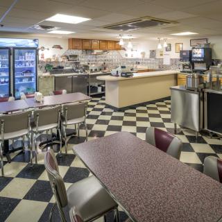 Interior view of a classic diner with checkered flooring and seating arrangements.