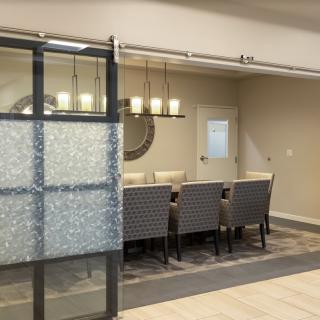 A modern dining room with a sliding glass door and elegant chandelier.