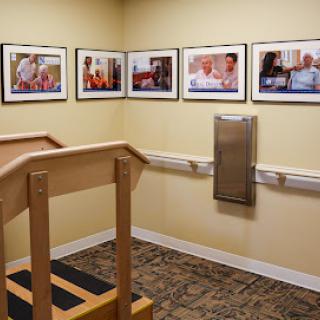 A therapy room featuring a wooden ramp and framed photographs on the wall.