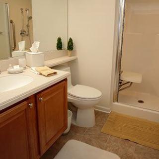 A clean and tidy bathroom with a toilet, sink, and shower.