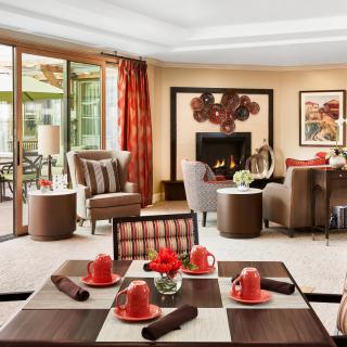 A stylish living room with red accents and a cozy fireplace.