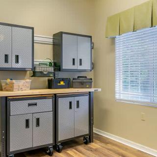 A well-organized room with storage cabinets and a workbench.