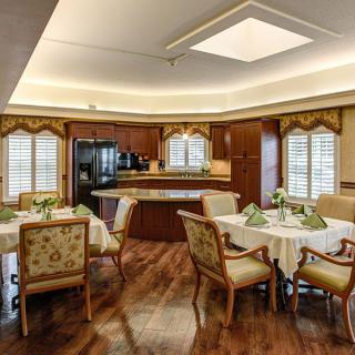 A tastefully decorated dining area with wooden furniture and an adjoining kitchen.