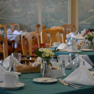 A beautifully set dining table in a restaurant with elegant decor and fresh flowers.