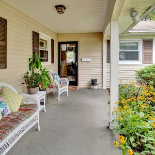 A cozy porch with wicker furniture and vibrant flowers, offering a welcoming entrance to the home.