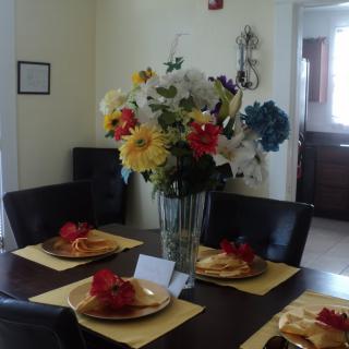 A dining table elegantly set with vibrant floral centerpiece and coordinated place settings.