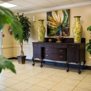 A stylish lobby featuring a wooden console table, decorative vases, and vibrant artwork.