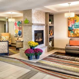A modern lobby area featuring a cozy fireplace, vibrant artwork, and comfortable seating.