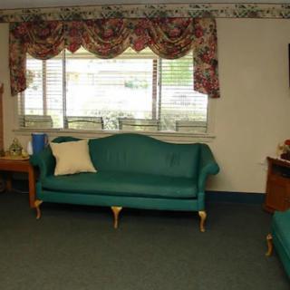 A vintage-style living room with a teal sofa and floral curtains.