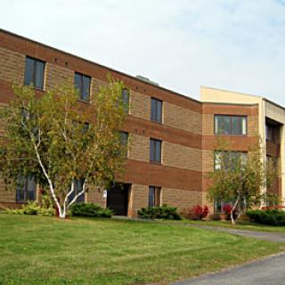 A modern brick building with landscaped surroundings.