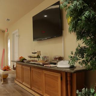 A cozy living room setup featuring a wooden cabinet adorned with snacks and a mounted TV.
