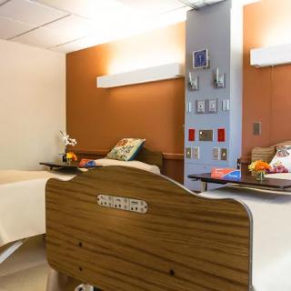 A hospital room with two beds and medical equipment.