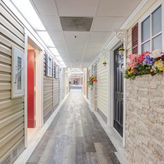 A brightly lit hallway with decorative walls and colorful flowers.