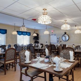 Elegant restaurant dining room with neatly arranged tables and chandeliers.