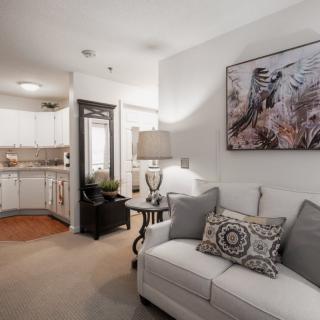 A cozy living room with a white sofa, decorative pillows, and artwork on the wall.