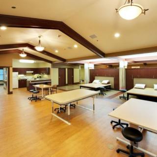 Spacious rehabilitation center therapy room with multiple treatment tables.