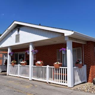 A charming building with a white railing and flower pots under a clear blue sky.