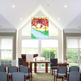 A serene chapel interior with stained glass and an altar.
