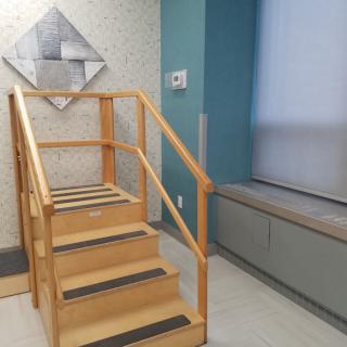 A wooden staircase setup in a rehabilitation or physical therapy room.