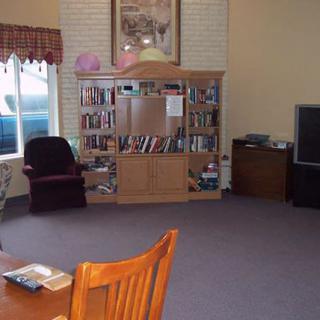 A cozy living room with a bookshelf, television, and seating area.