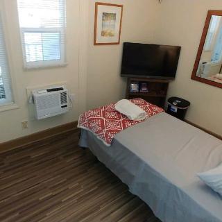 A cozy, small bedroom with a single bed and TV.