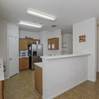 A modern kitchen with wooden cabinets, stainless steel appliances, and a white countertop.