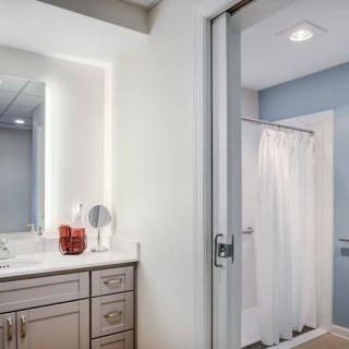 A modern bathroom featuring a vanity with a mirror and a shower area separated by a curtain.