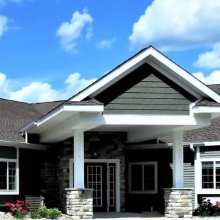 A modern residential house with a prominent entrance and a clear blue sky in the background.