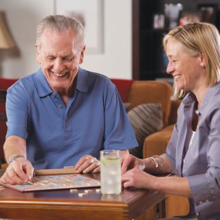 Two people enjoying a board game together, smiling and relaxed indoors.
