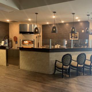 A modern restaurant interior featuring a sleek counter and seating area.