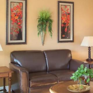 A cozy living room with a leather sofa, accented by wall art and ambient lighting.