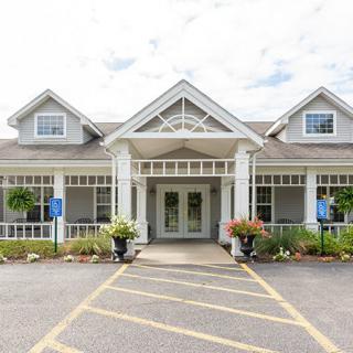 A traditional-style building with a symmetrical entrance and surrounding greenery.