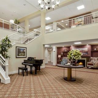 Elegant lobby with a grand staircase and piano.