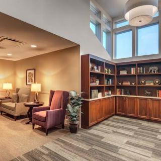 A cozy library reading area featuring comfortable seating and well-stocked bookshelves.